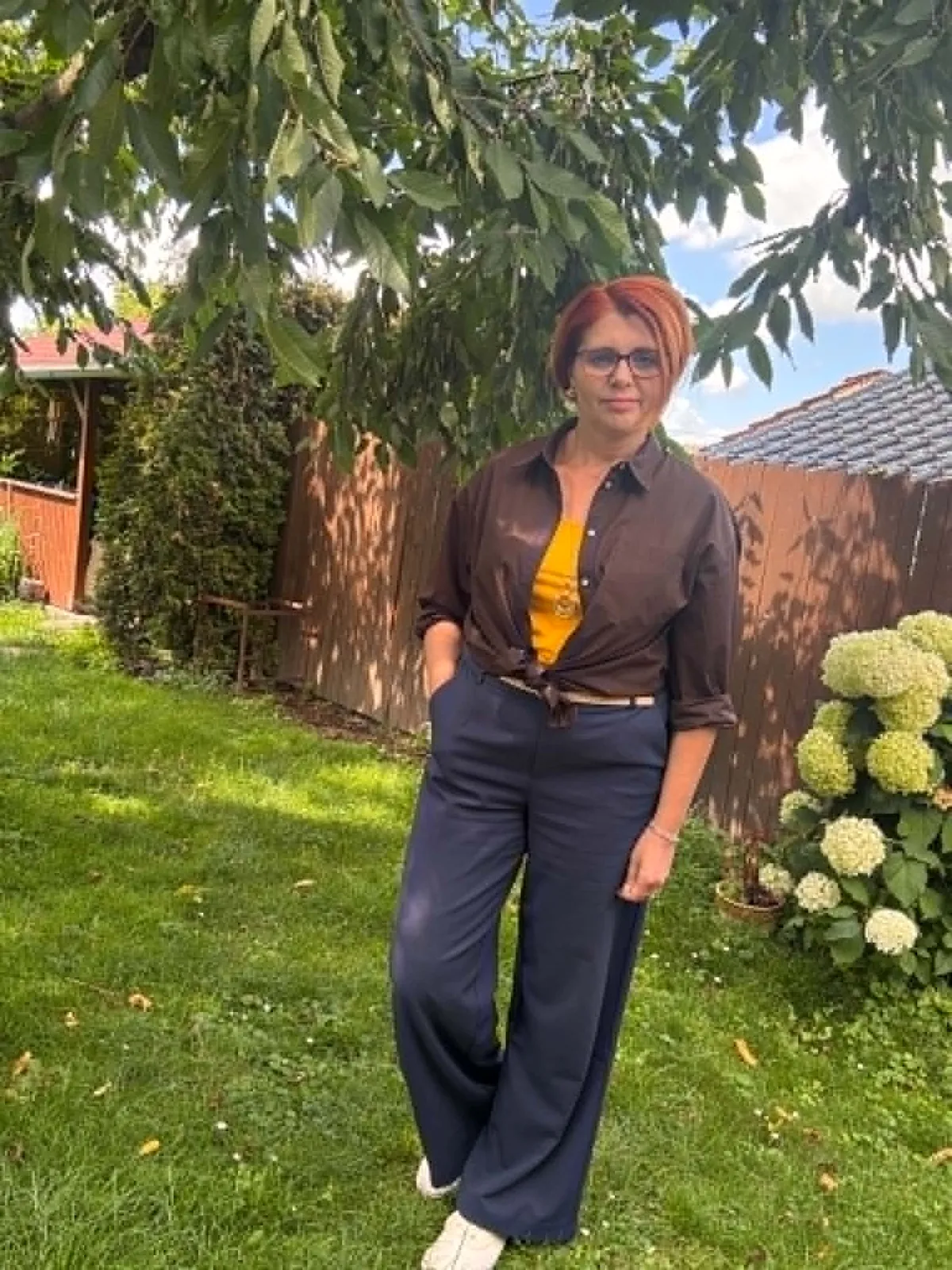 Osobní styling: hořčicový top, hnědá košile, široké tmavě modré kalhoty a bílé tenisky